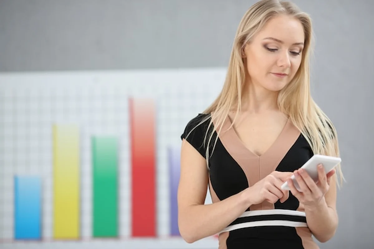 Blond kobieta handluje na rynku Forex przy użyciu oferty mobilnej