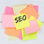 Komputer na biurku z notatkami i papierem